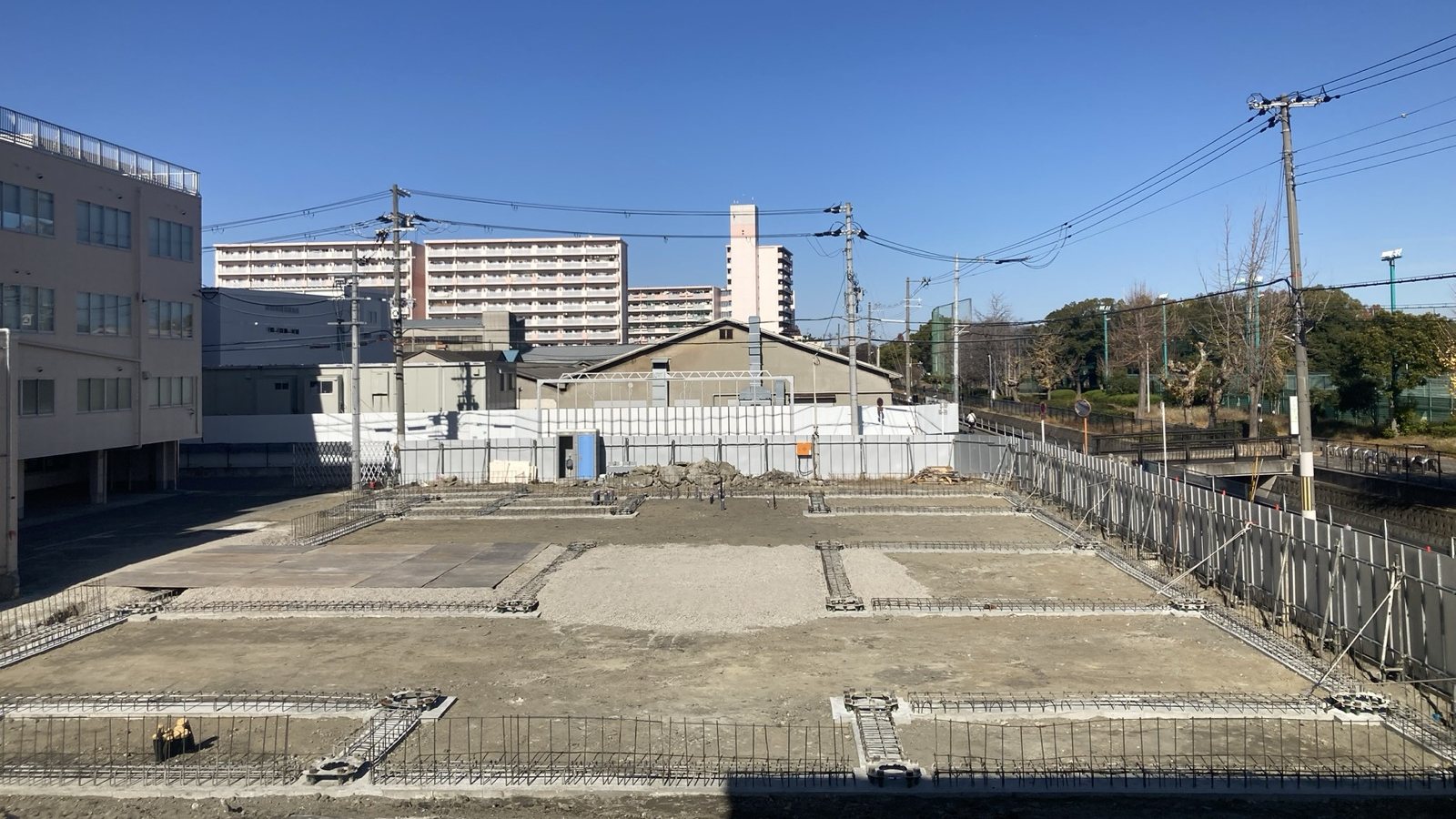 基礎工事。柱脚と地中梁の配筋が並ぶ敷地全景